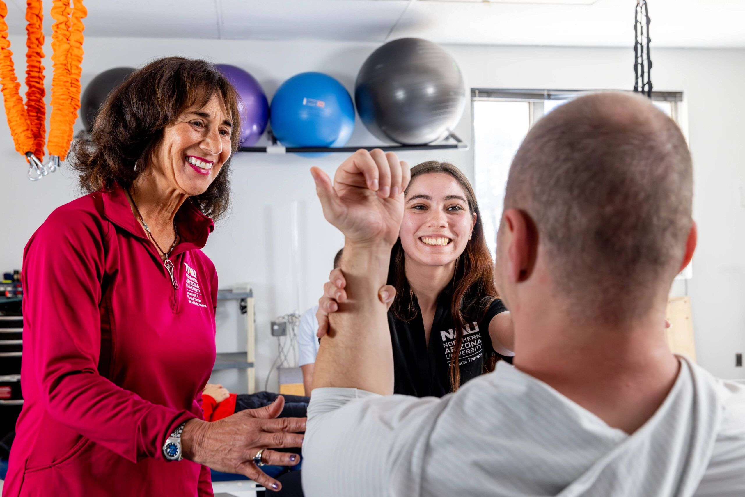 An NAU Physical Therapy student assists a patient with the help of her professor.