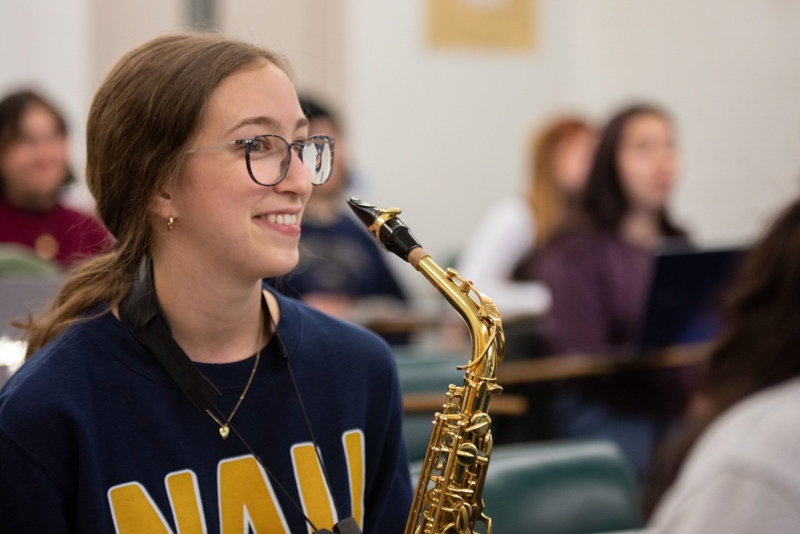 An NAU music student smile while holding her saxaphone.
