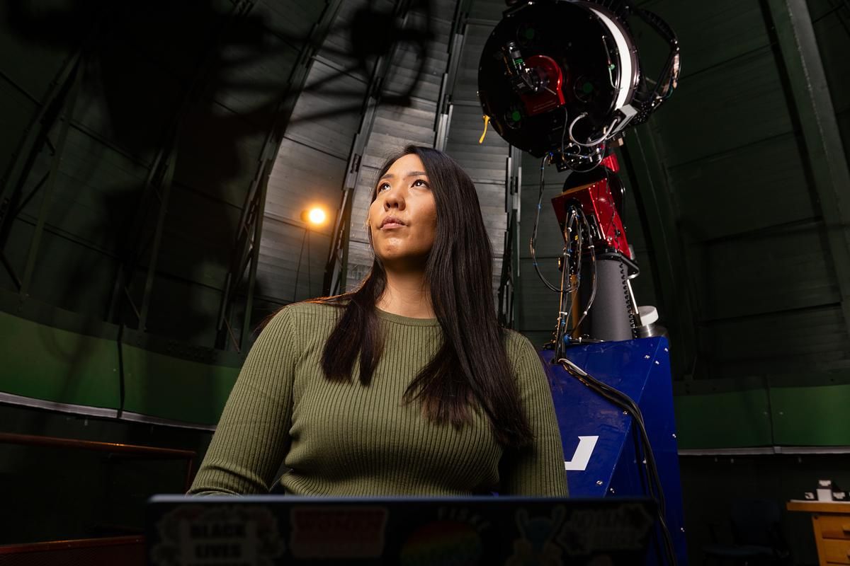Ana Morgan stands in front of a telescope.