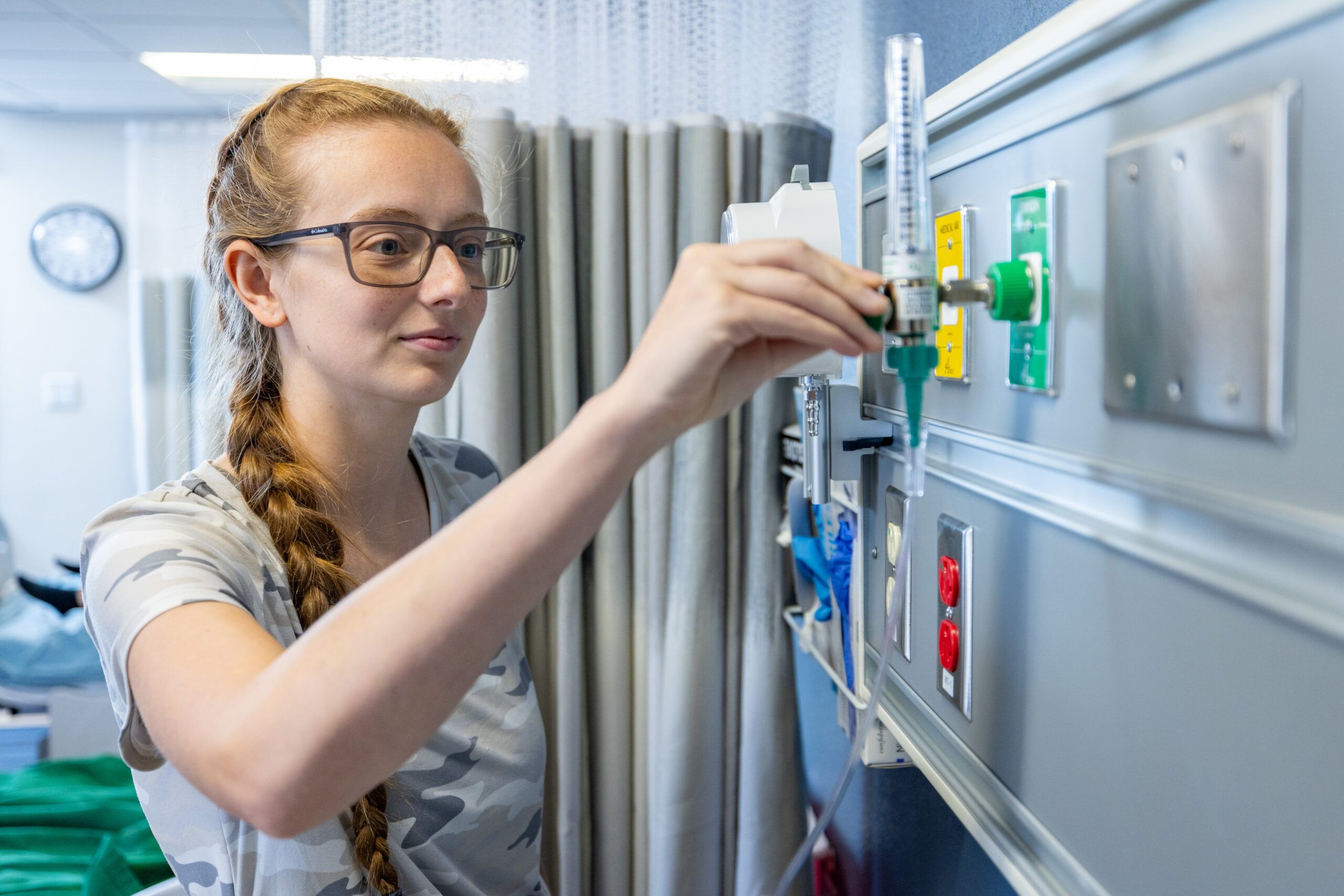 Doctor of Physical Therapy, Sara Thomasson adjusts the settings of a hospital machine.