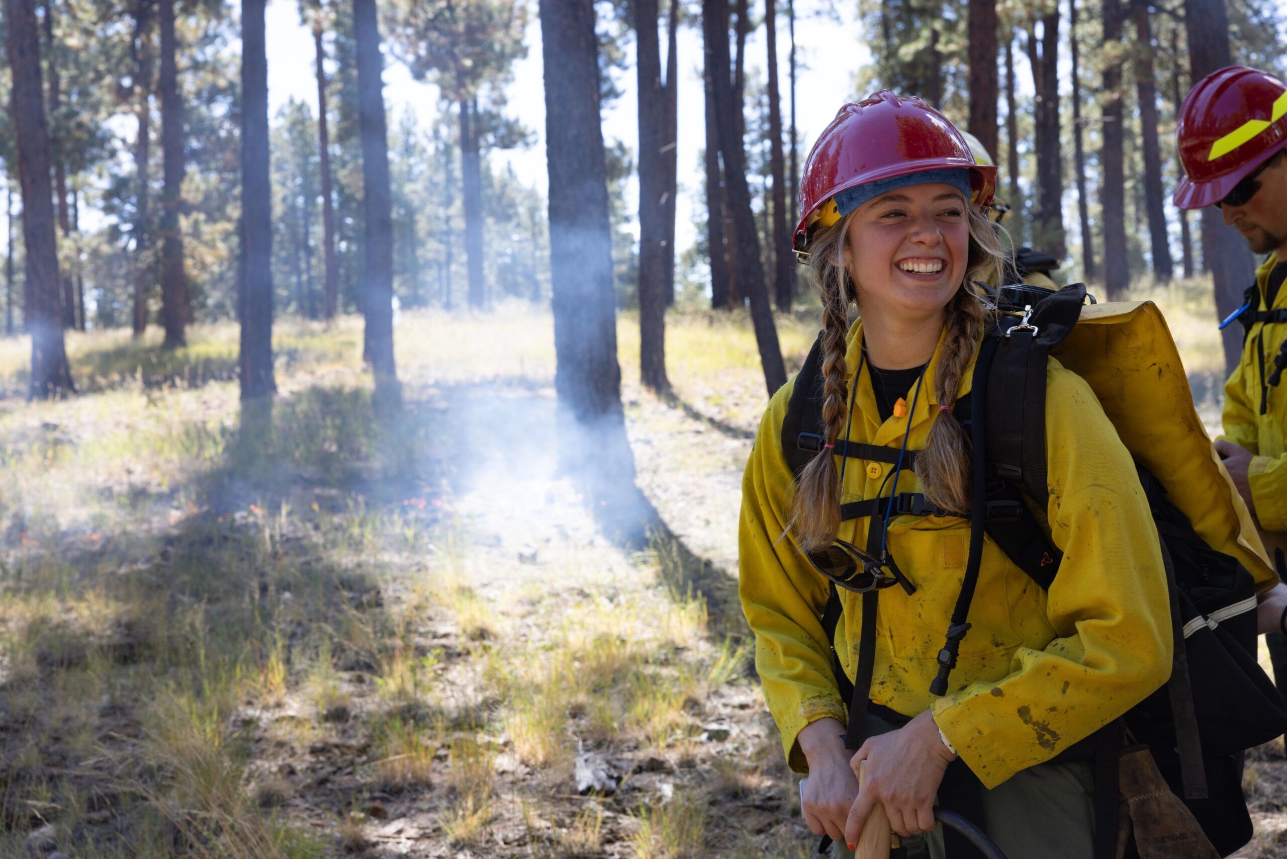 An NAU forestry student smiles while assisting with a prescribed fire for the first time.